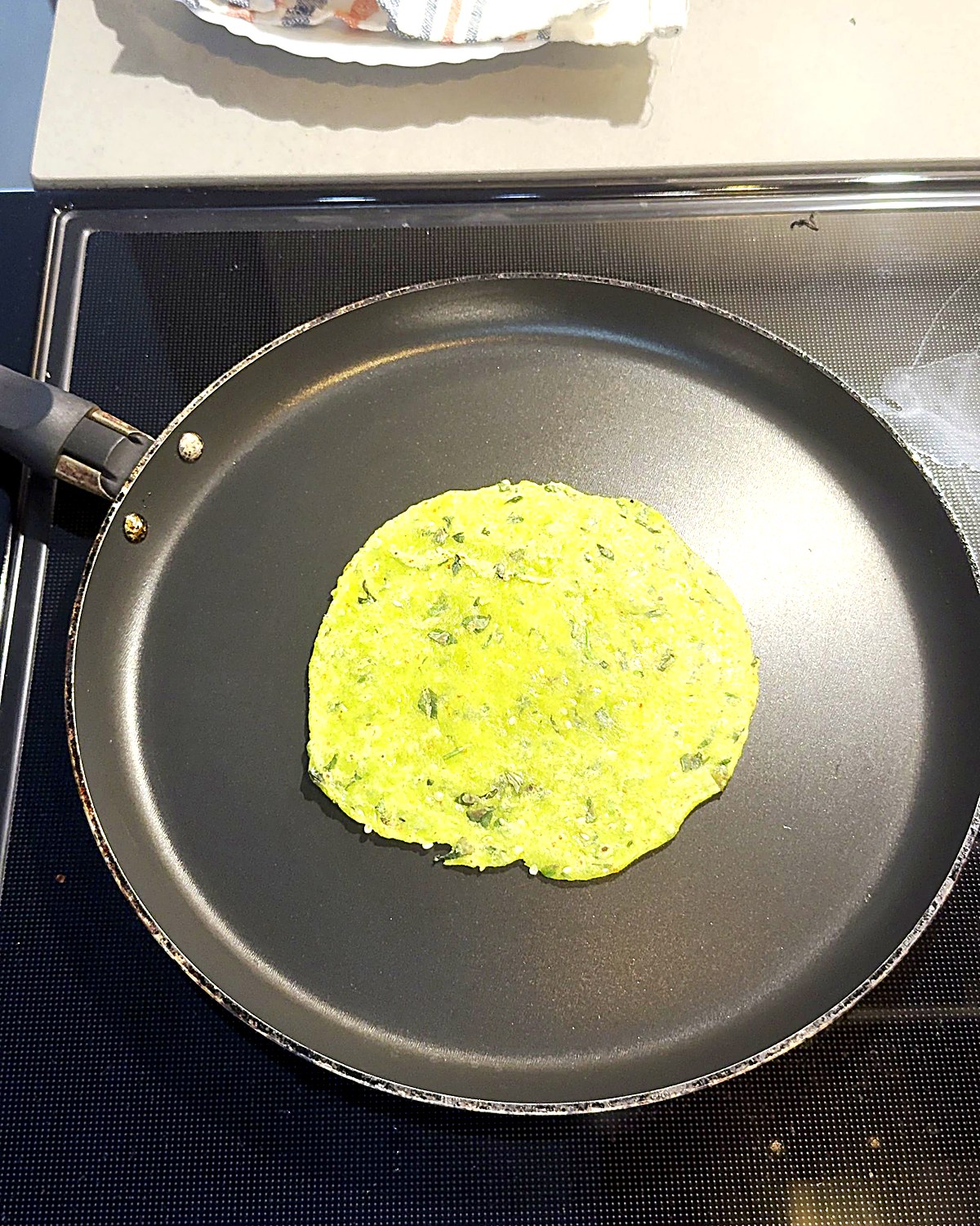 Roasting methi thepla on a tawa
